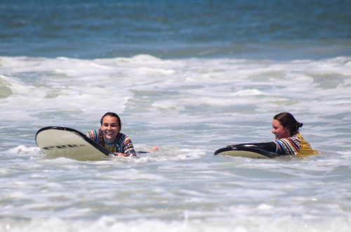 Zwei Mädchen auf Surfboards, lachend