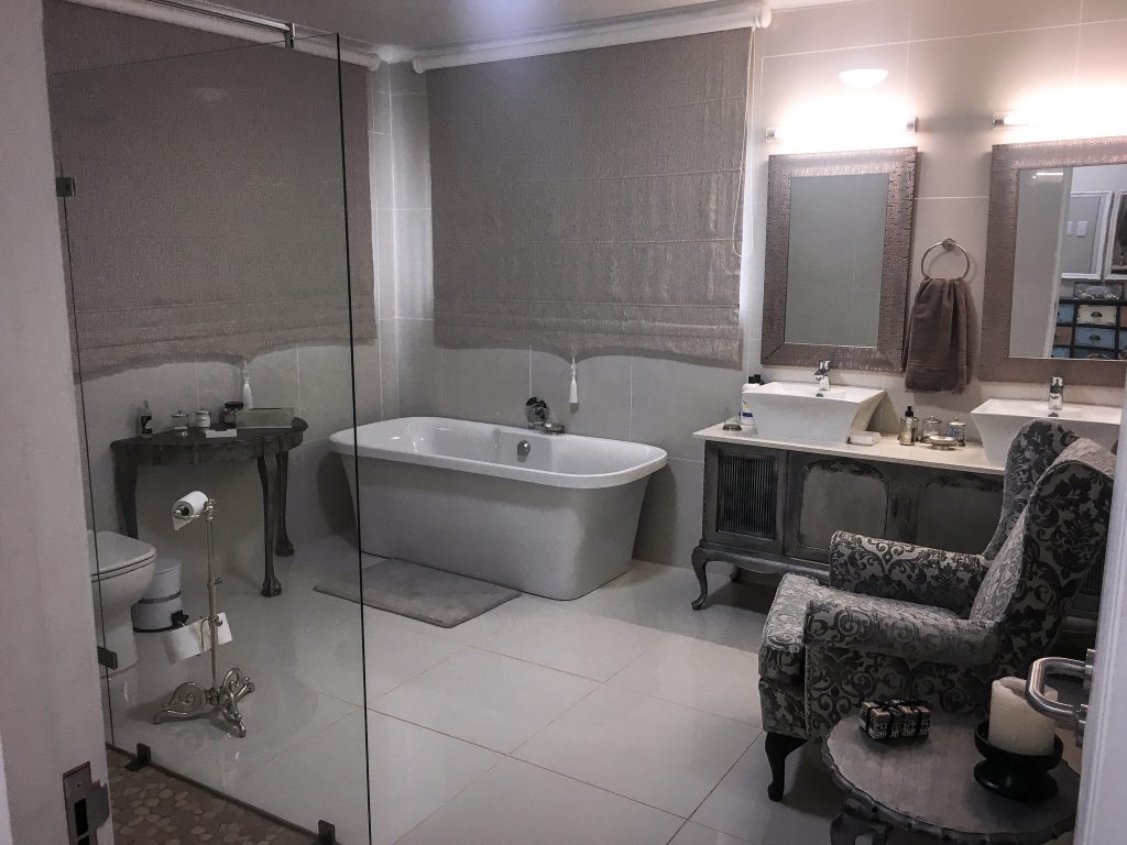 Badezimmer mit großer Badewanne, Dusche und Sessel